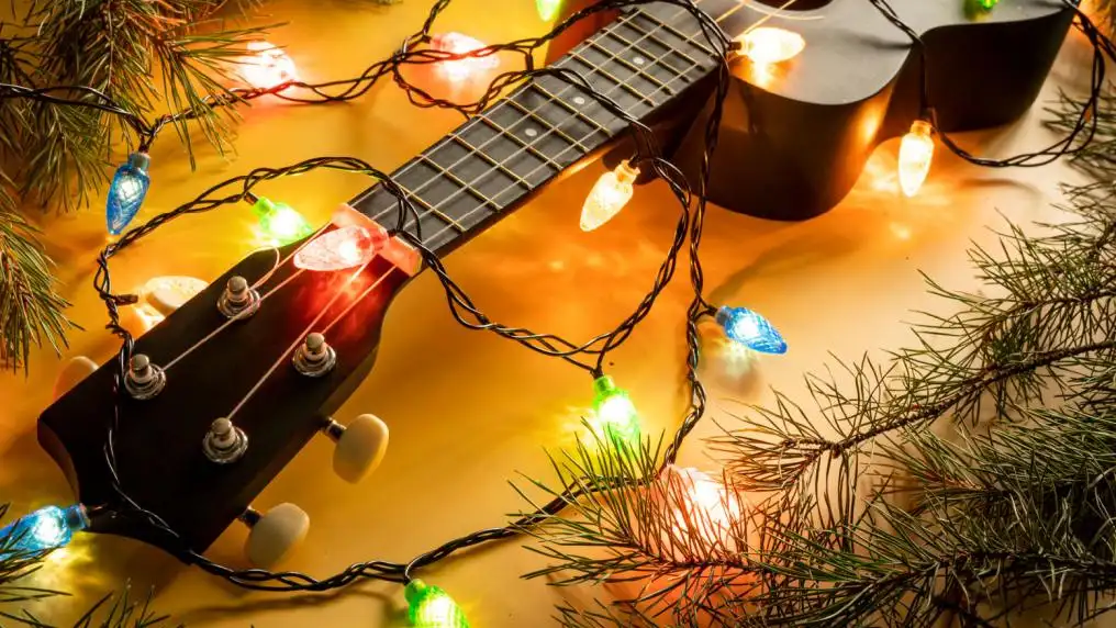 Kind leert gitaar spelen in les