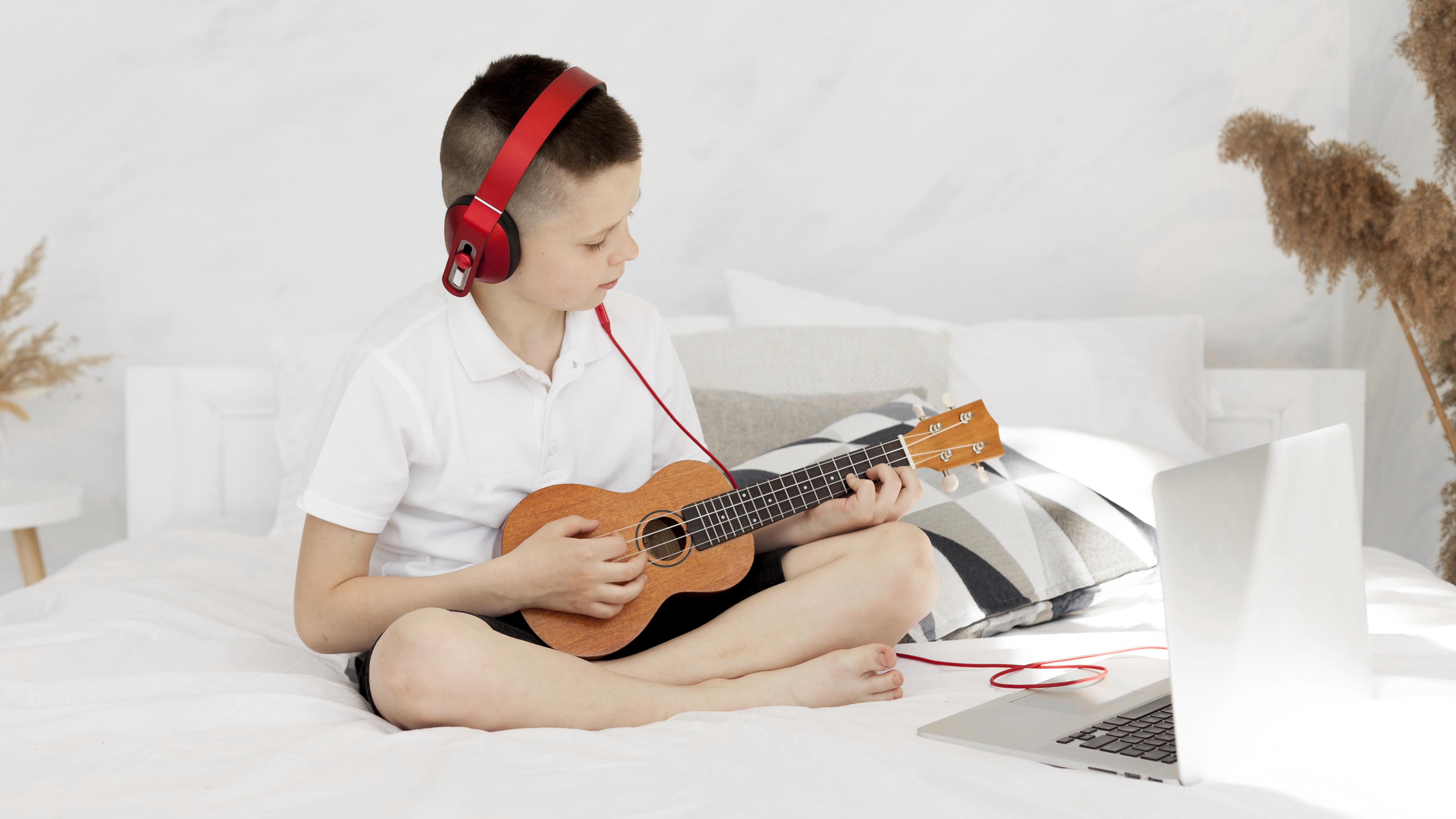 Docent geeft online ukeleleles via een laptop