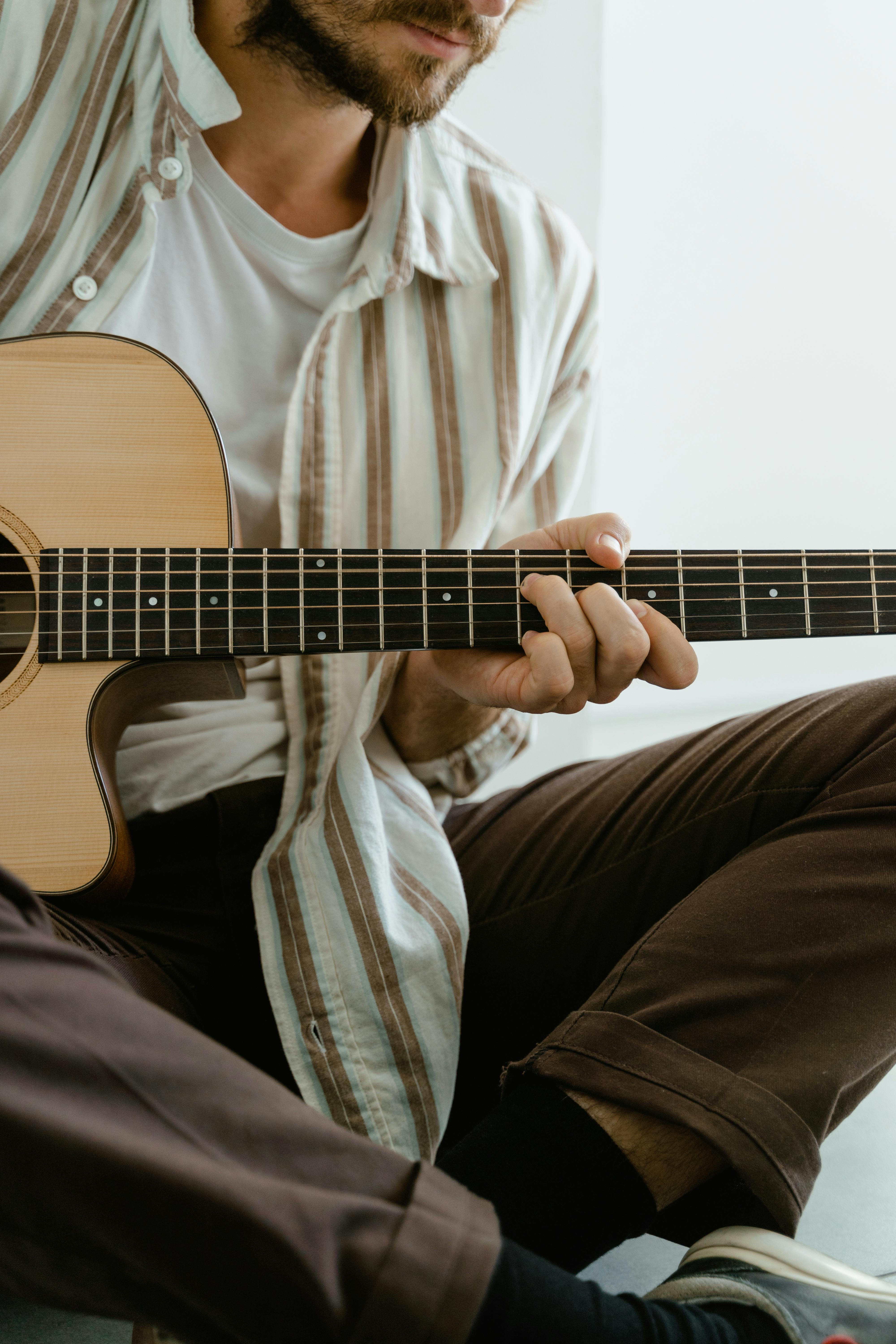 Volwassene speelt gitaar tijdens les